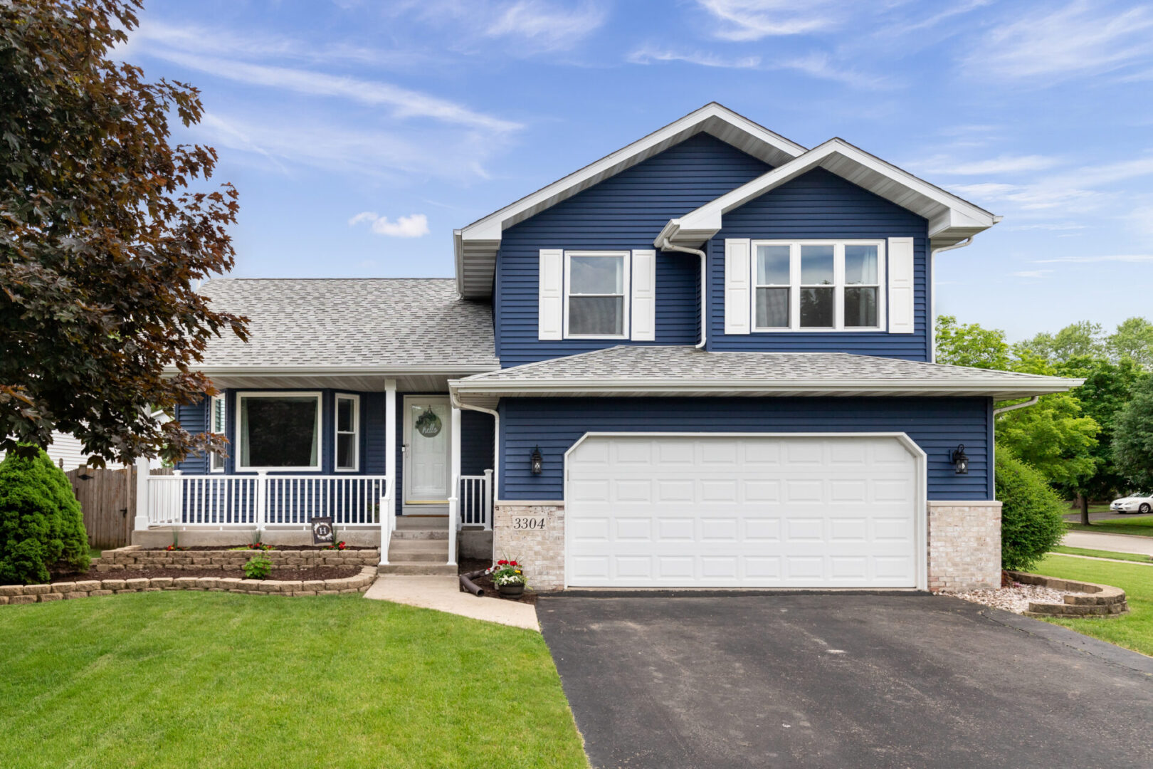 Two-story blue house with white trim and a double garage.
